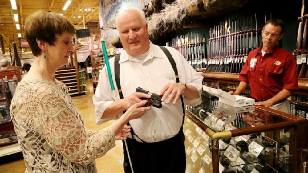 Un client aveugle testant une arme dans un magasin sp&eacute;cialis&eacute;. 