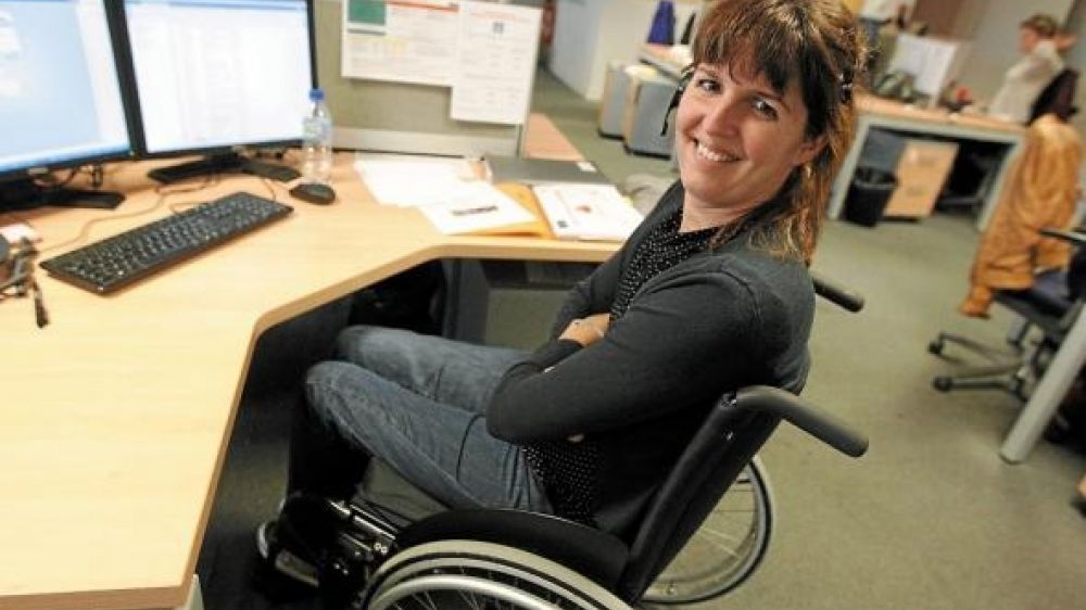 Pascaline, 32 ans travaille &agrave; son bureau en fauteuil roulant
