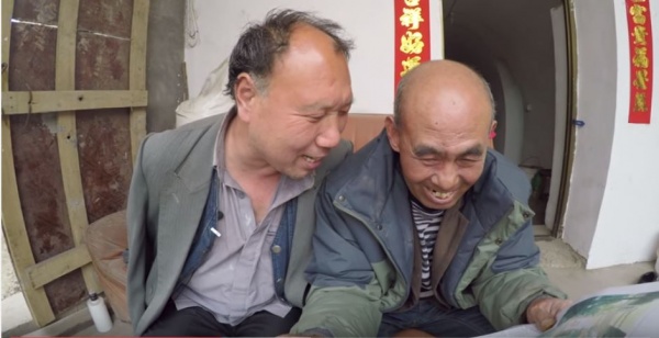 Jia Wenqi (à gauche) lisant le journal à son ami Jia Haixia.
